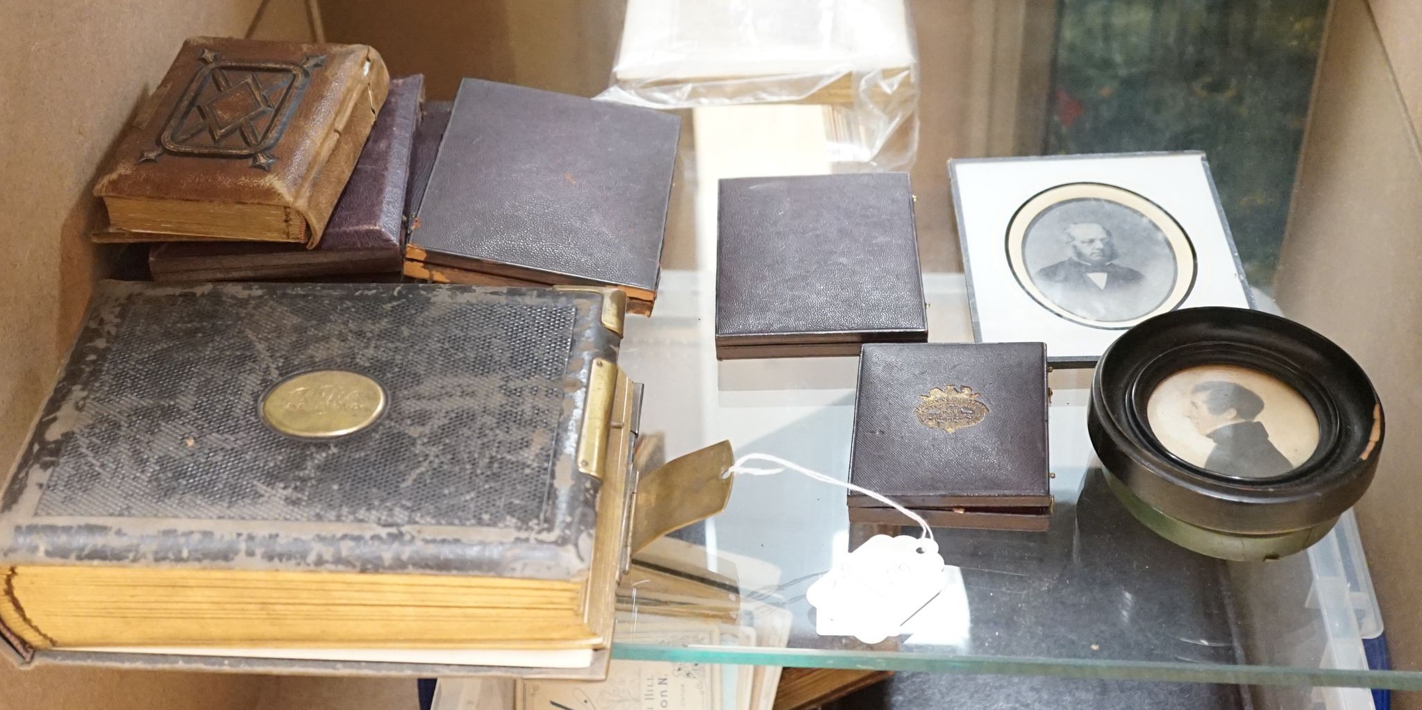 A collection of Victorian photographs etc including a tinted daguerreotype, three portrait miniatures and cabinet cards